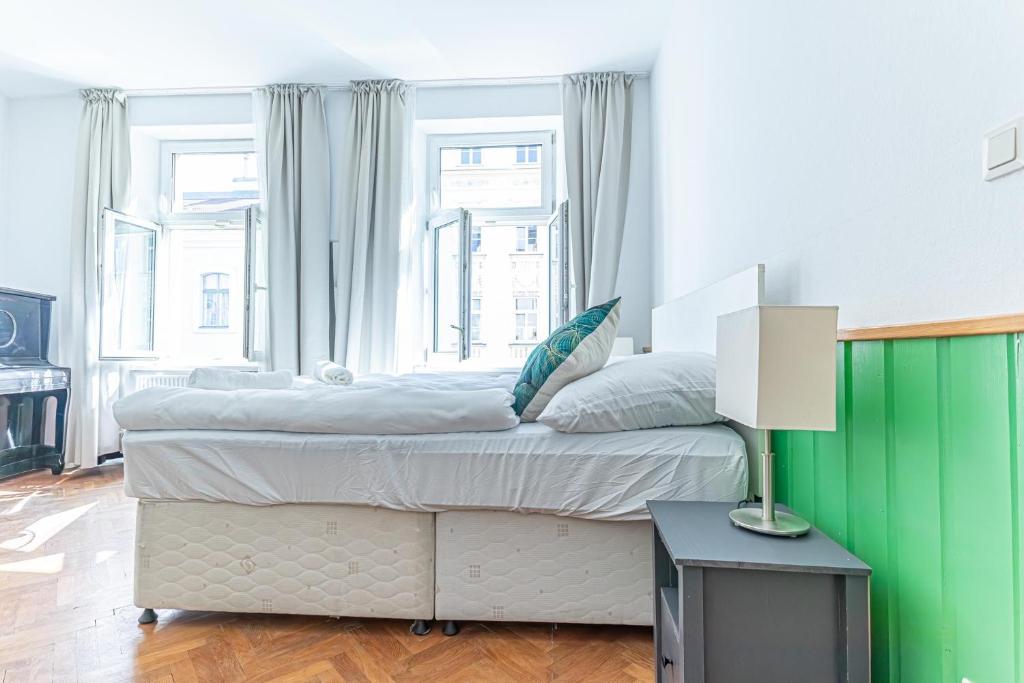 a bedroom with a large bed with a green wall at Convenient 3-BR Shared Apt, 15 Min to Landstraße Hub in Vienna