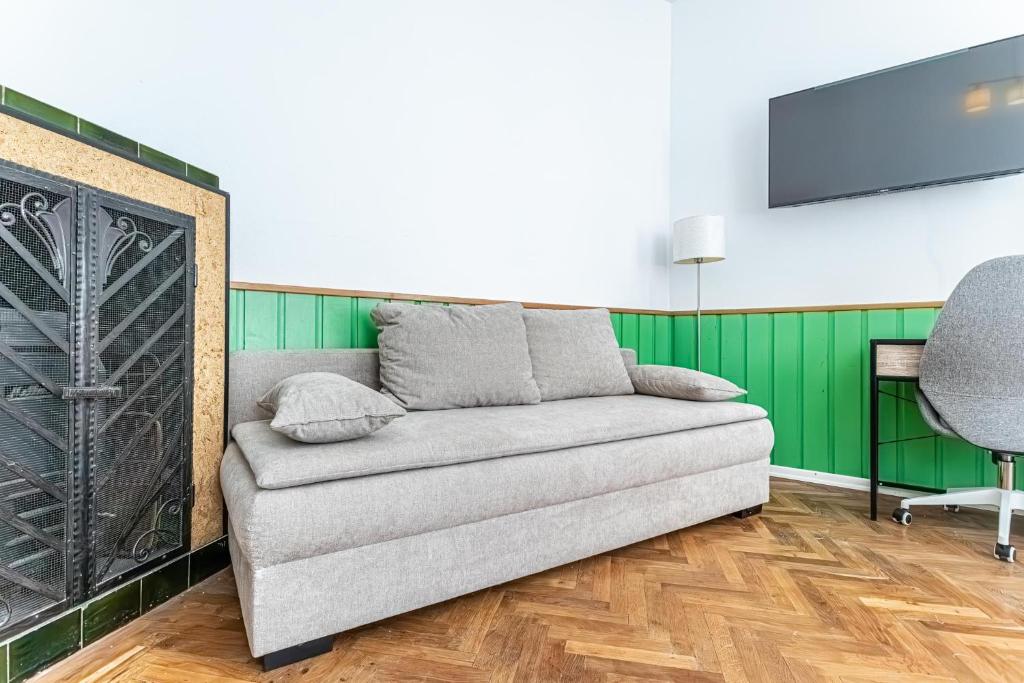 a living room with a couch and a tv at Convenient 3-BR Shared Apt, 15 Min to Landstraße Hub in Vienna
