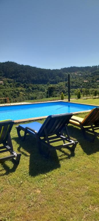 two picnic tables in front of a swimming pool at Casa de Silvares - Piso inferior in Carvalho