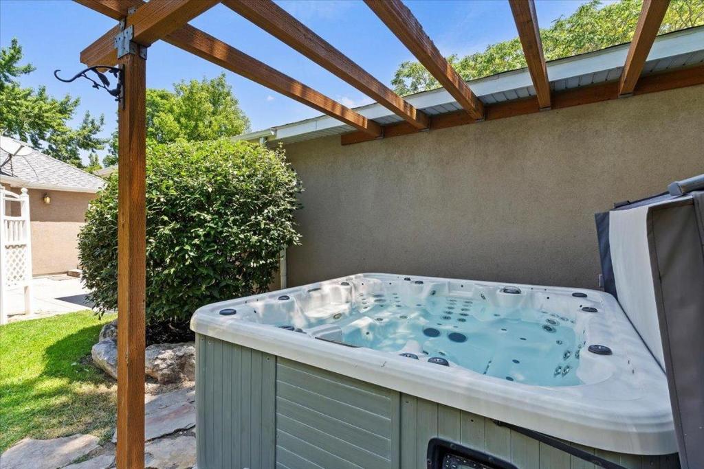 a hot tub in a backyard with a pergola at Riviera Retreat in Salt Lake with Private Hot Tub and Theater in Millcreek