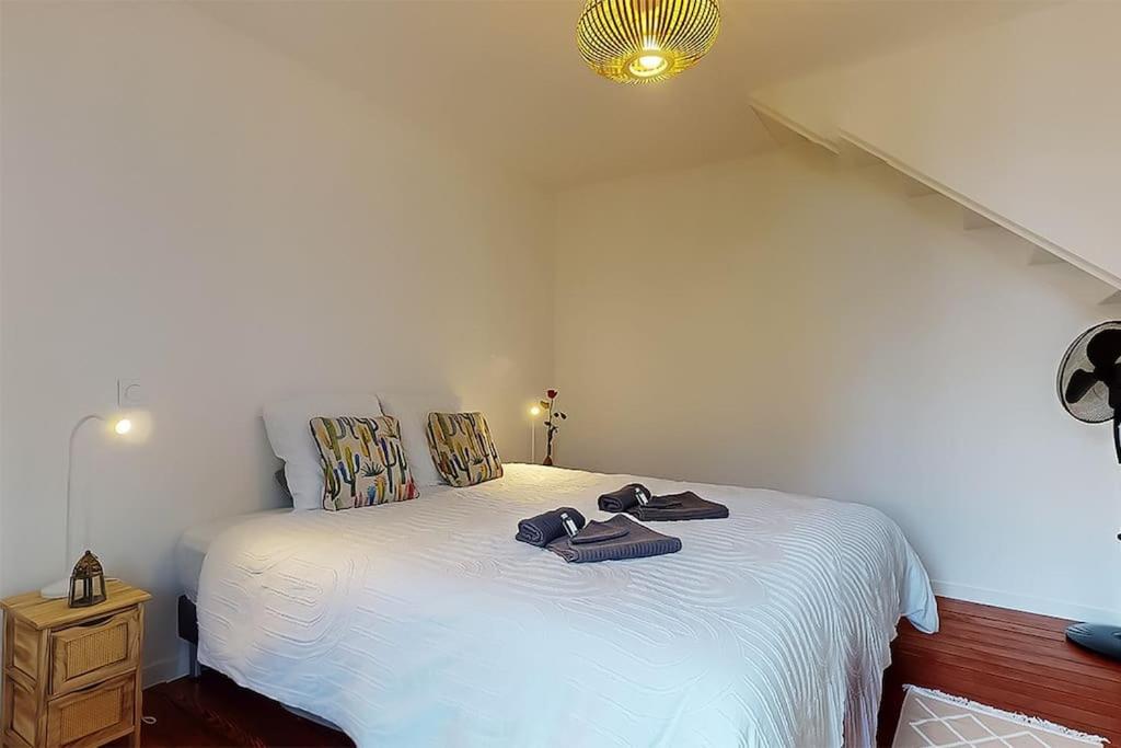 une chambre avec un lit blanc avec des serviettes dessus dans l'établissement Maison de ville proche Gare-Terrasse-WIFI, à Alfortville