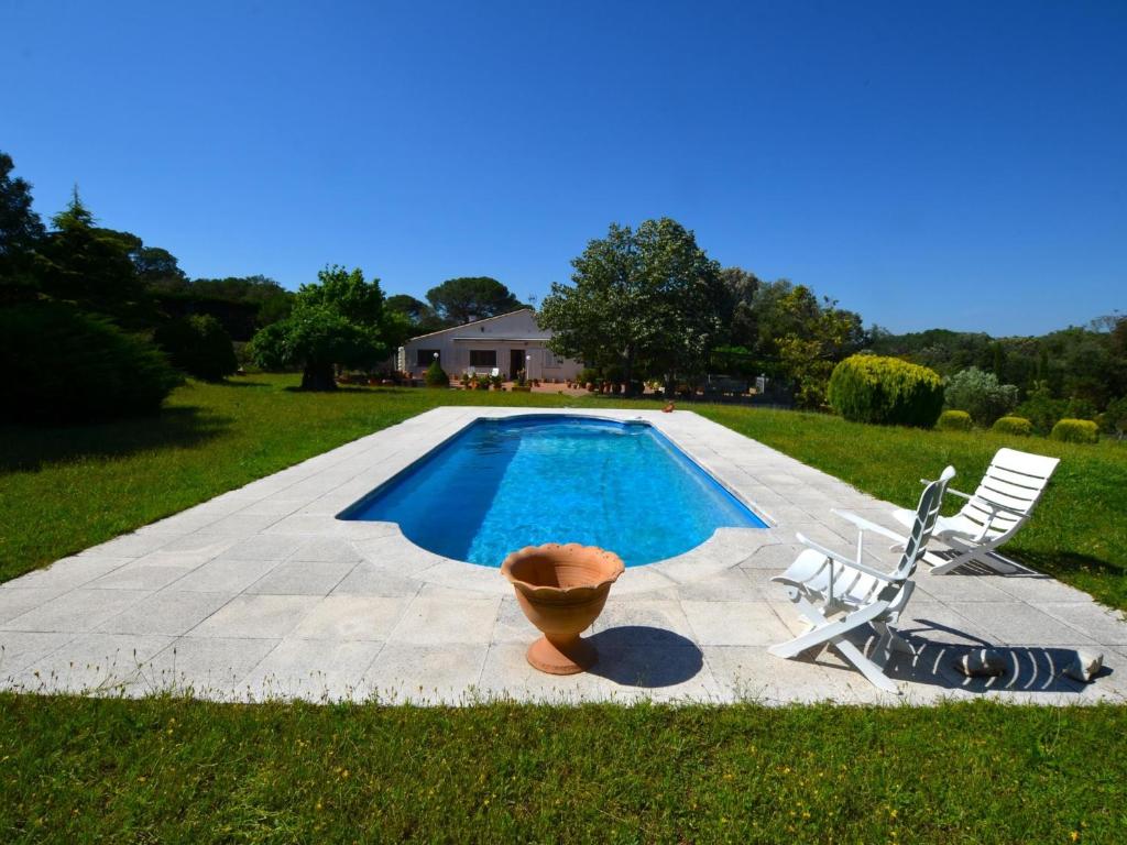 a pool with a chair and a vase next to it at Can Torrent 10 Km Lloret De Mar in Vidreres