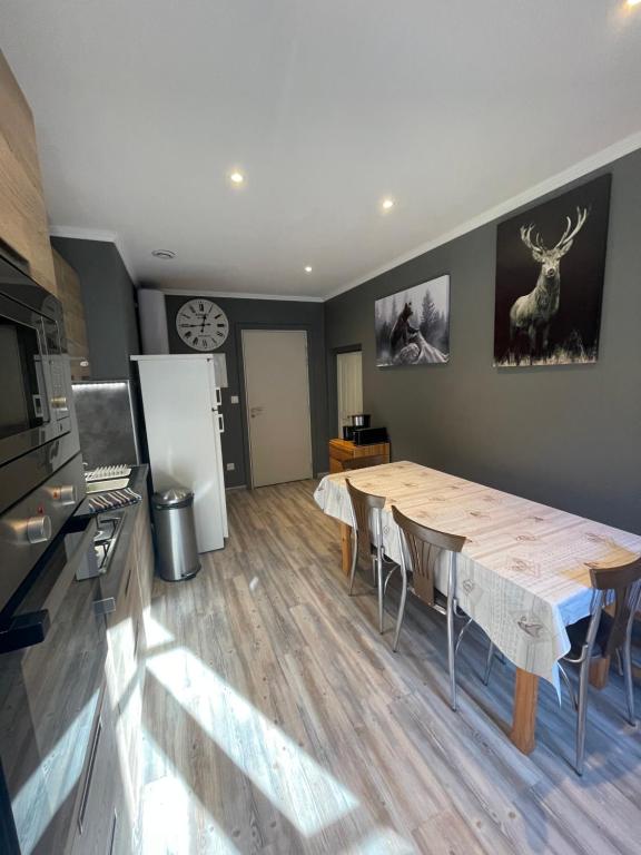 une cuisine et une salle à manger avec une grande table en bois dans l'établissement la montagnette T2 MAISON EN TRAVAUX DE 10H A 17H, à Moutiers