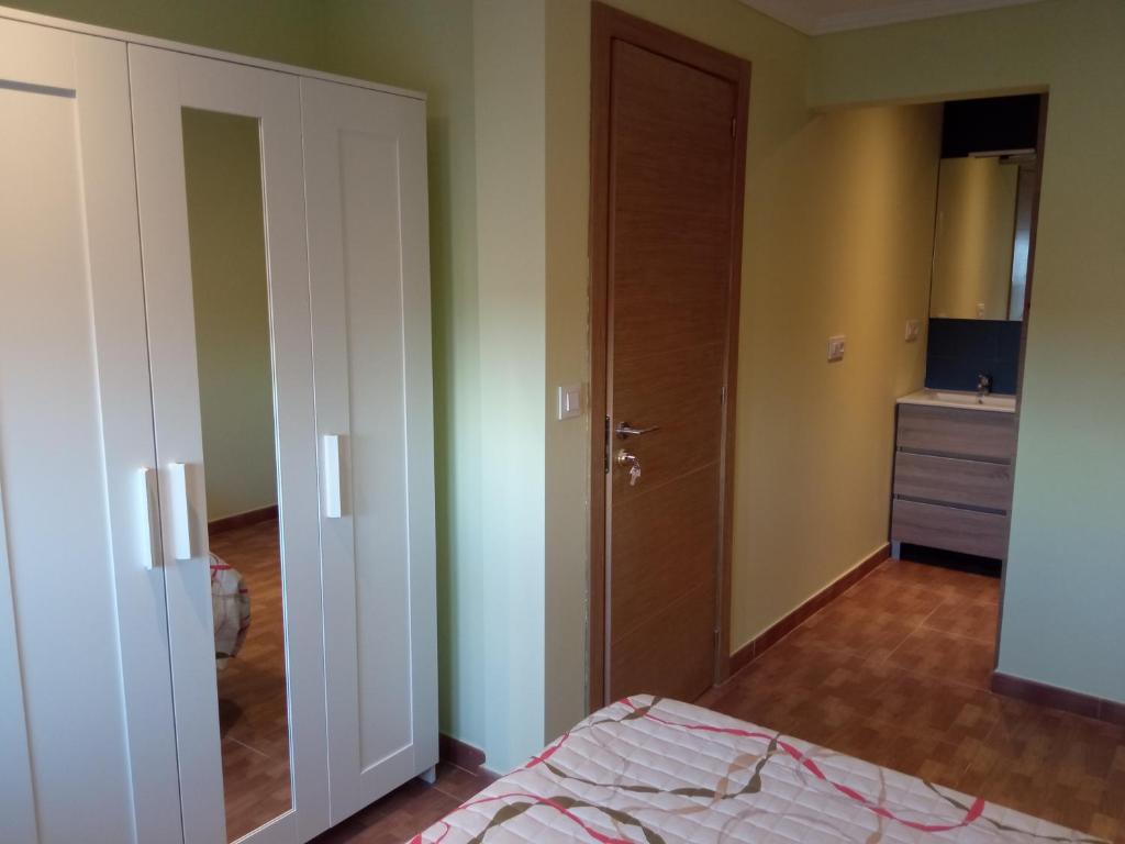 Pokój z sypialnią z łóżkiem i drzwiami w obiekcie Habitación con baño cambados w mieście Pontevedra