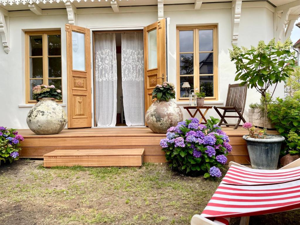 a porch of a house with three large vases at Weißt Du noch - Gästehäuser & Suiten in Kühlungsborn