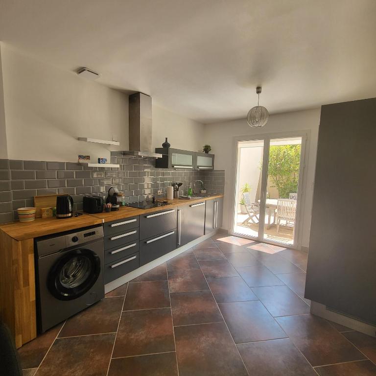 une cuisine avec un lave-linge au milieu dans l'établissement Maison 6 personnes 3 chambres Aéroport-Plages, à Marignane