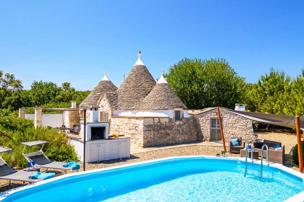 une vue extérieure d'une maison avec piscine dans l'établissement Villa Trullo Selva Grande by Villa Plus, à Martina Franca