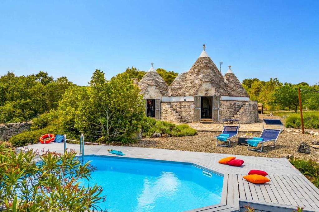 une maison avec piscine devant un immeuble dans l'établissement Villa Trullo Selva Piccolo by Villa Plus, à Martina Franca