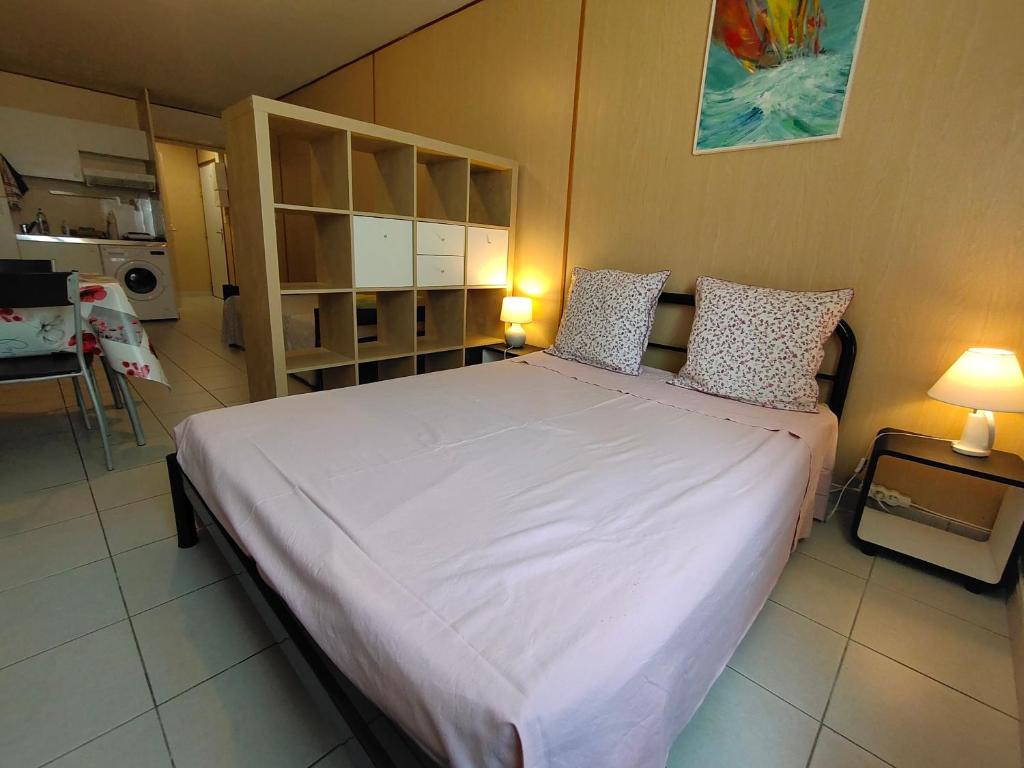 une chambre avec un grand lit blanc avec deux oreillers dans l'établissement Grand Studio à La Rochelle Près de Vieux Port, à La Rochelle