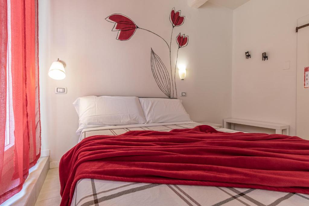 a red blanket on a bed in a room at Suite Modena al Centro - Affitti Brevi Italia in Modena