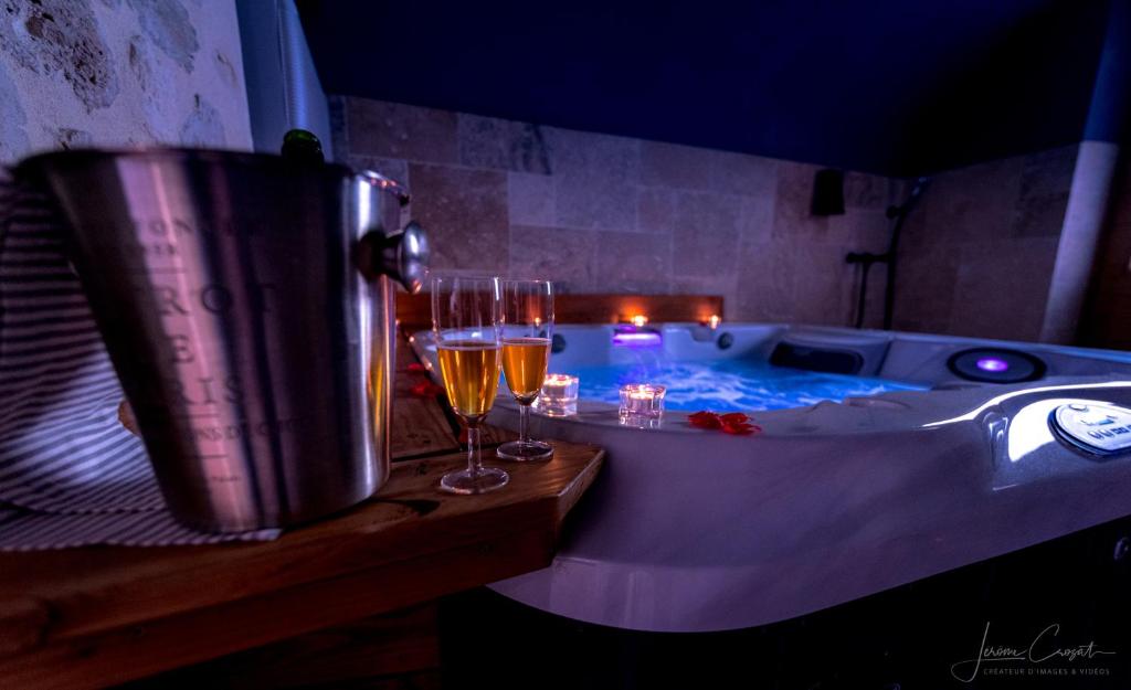 a tub with two glasses of wine and two glasses of champagne at Logis de Cupidon in Châteauneuf-du-Rhône