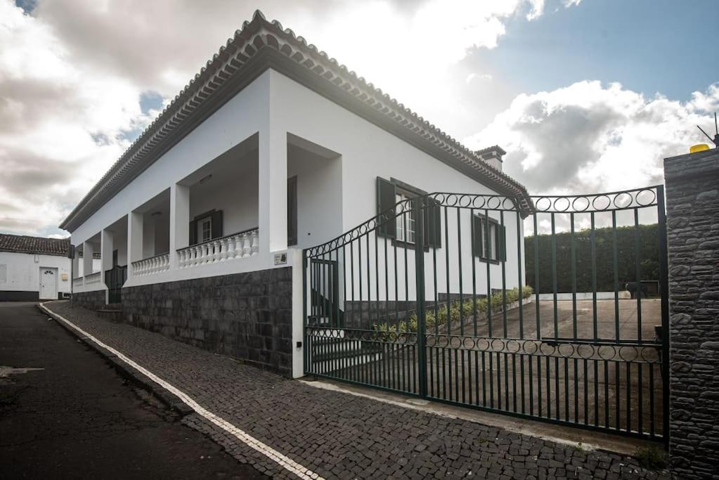 a white house with a wrought iron fence at Casa Gabriel Barbosa in Lagoa