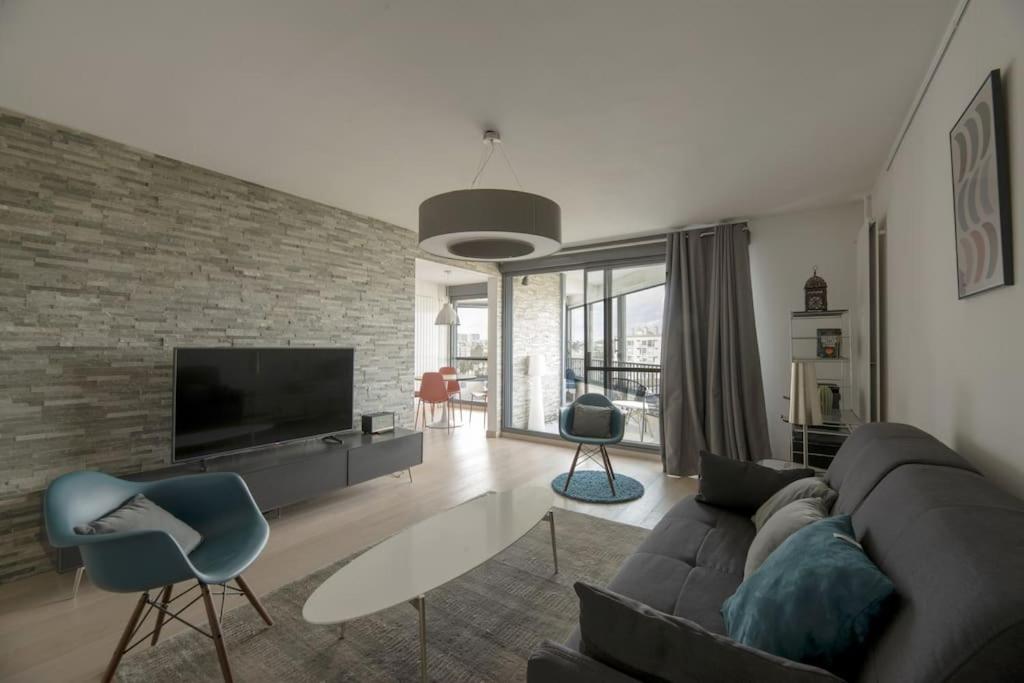 un salon avec un canapé et une télévision dans l'établissement L'Etoile, à Rennes