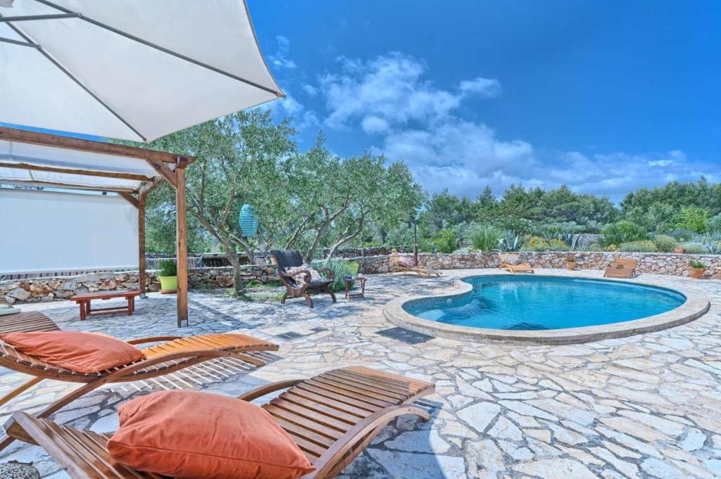 a patio with a pool and chairs and an umbrella at Spacious House with Private Pool in Stari Grad in Stari Grad