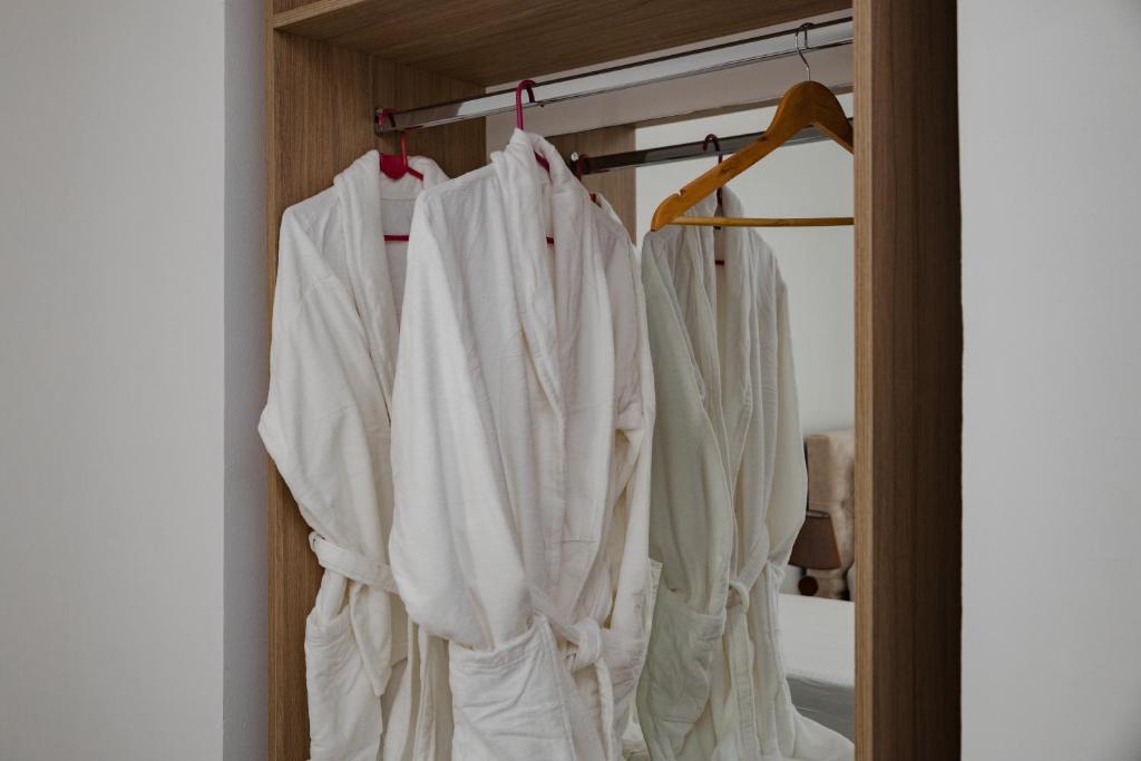 a closet with white shirts hanging on a rack at Riviera Hotel-City Center in Vlorë