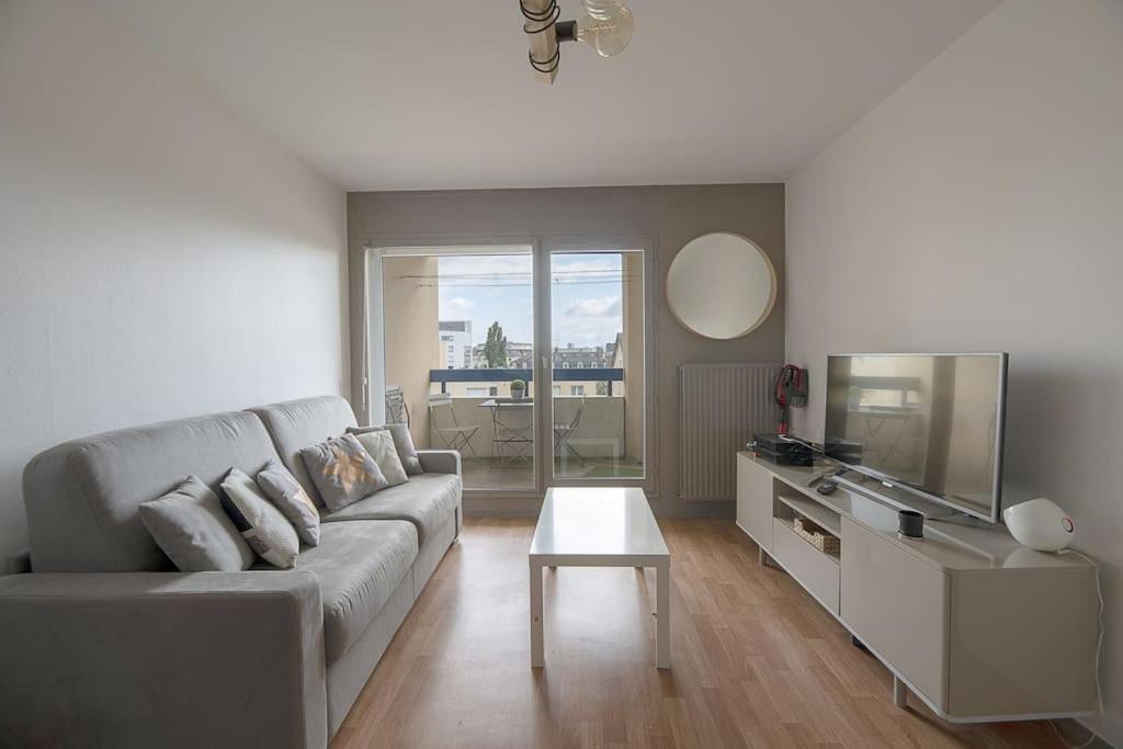 un salon avec un canapé et une télévision dans l'établissement Le Mail à Rennes, à Rennes