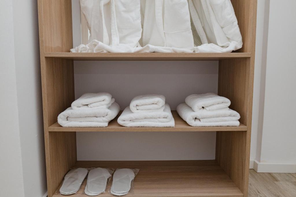 a closet with white towels on a shelf at Riviera Hotel-City Center in Vlorë