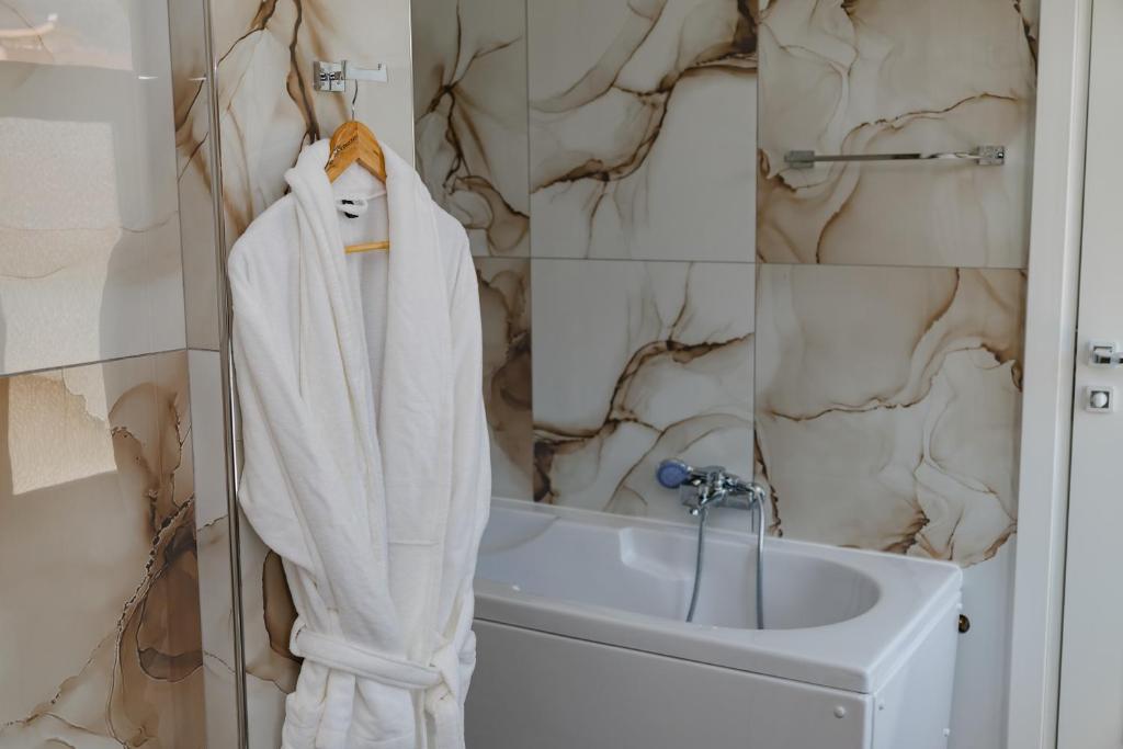 a bathroom with a white towel hanging next to a sink at Riviera Hotel-City Center in Vlorë
