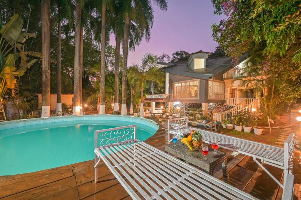 罗纳瓦拉Heritage Bliss By Mulberry Stays的一座带游泳池和房子的度假屋