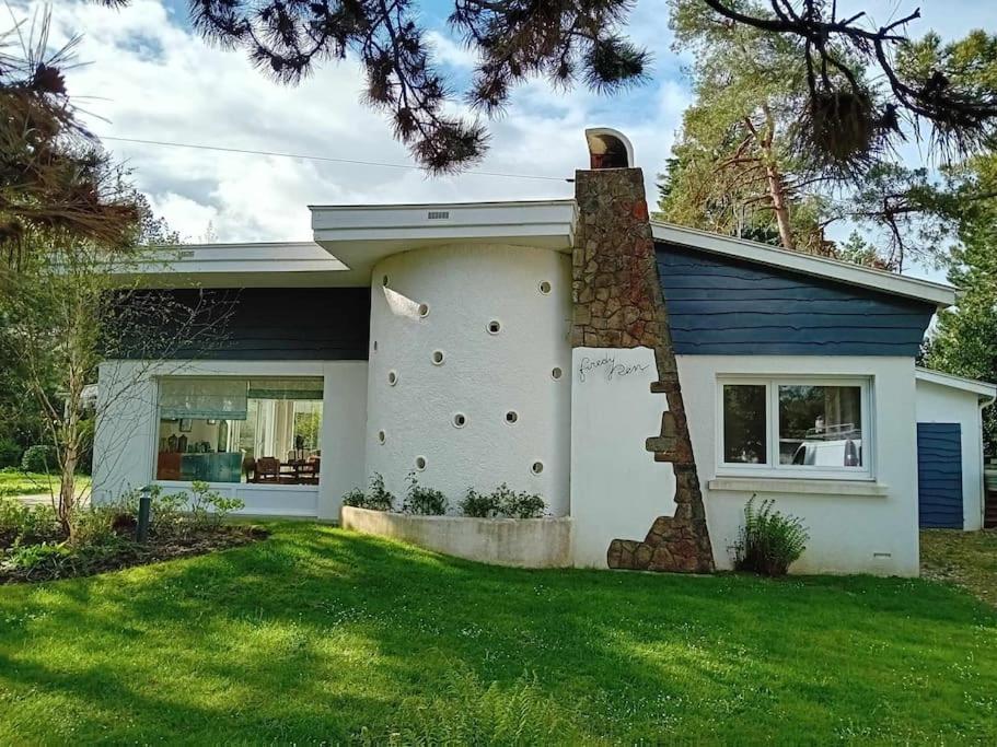 a white house with a brick chimney on the side of it at Maison entre Mer, Dunes et Forêt in Cucq