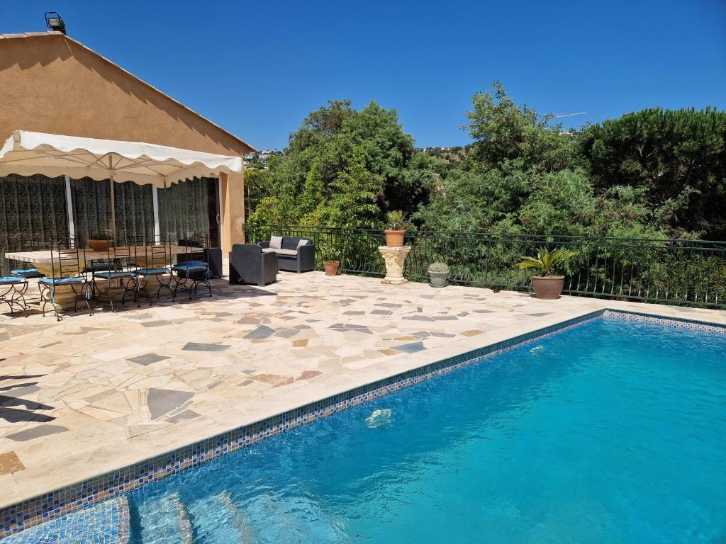 une piscine dans une cour avec une table et des chaises dans l'établissement Villa Sambracitaine, aux Issambres