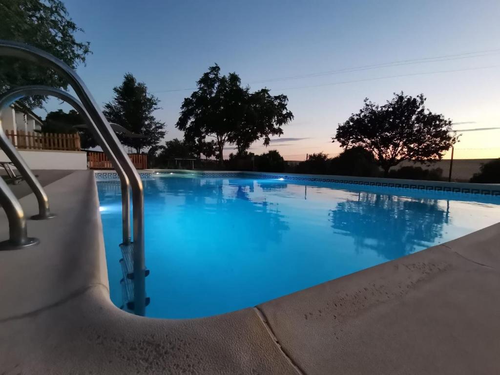 a large swimming pool with blue water at THE FERNANDEZs HOUSE in Hinojosa del Duque