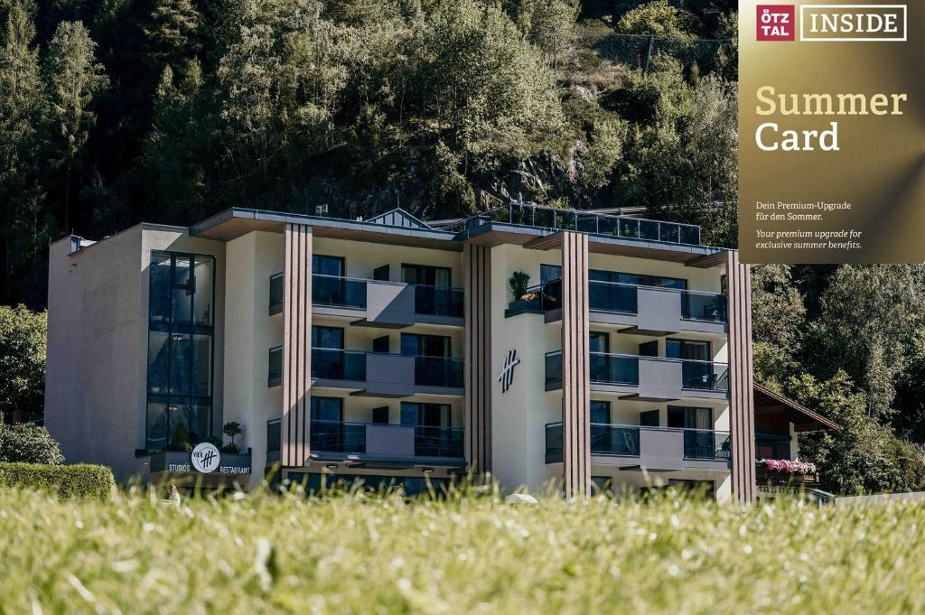 an image of a building with a summer garden at VIER Studios & Restaurant in Längenfeld