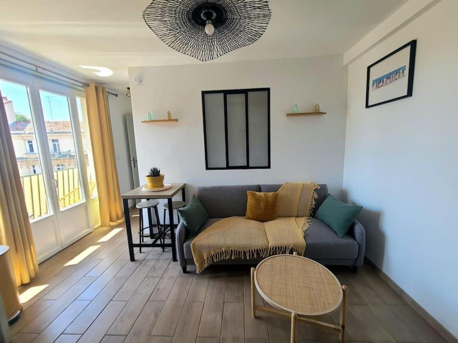 un salon avec un canapé et une table dans l'établissement Havre Lumineux avec Climatisation et Terrasse, à Montpellier