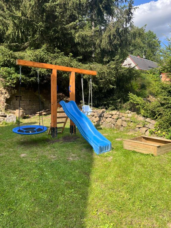 a playground with a blue slide in the grass at Chalupa Krásný Buk, České Švýcarsko in Krásná Lípa