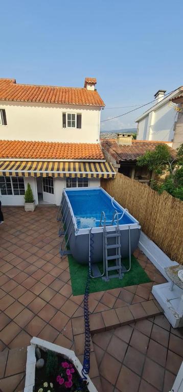 a swimming pool in a yard next to a house at Casa Independiente en Quintela - HomeyGalicia in Vigo