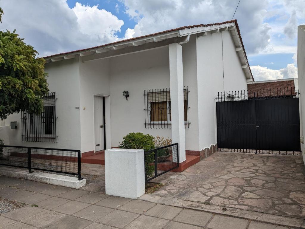 una casa blanca con una puerta negra en Casa Anne, en Tandil