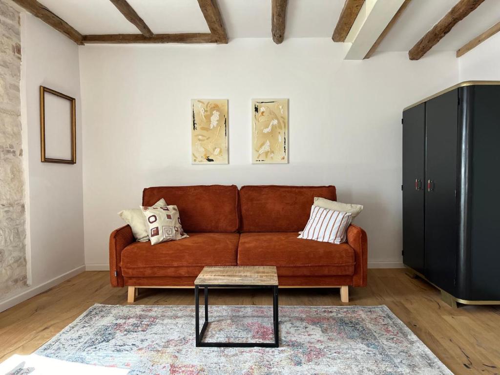 a living room with a brown couch and a table at Casa di Luna Rovigno in Rovinj