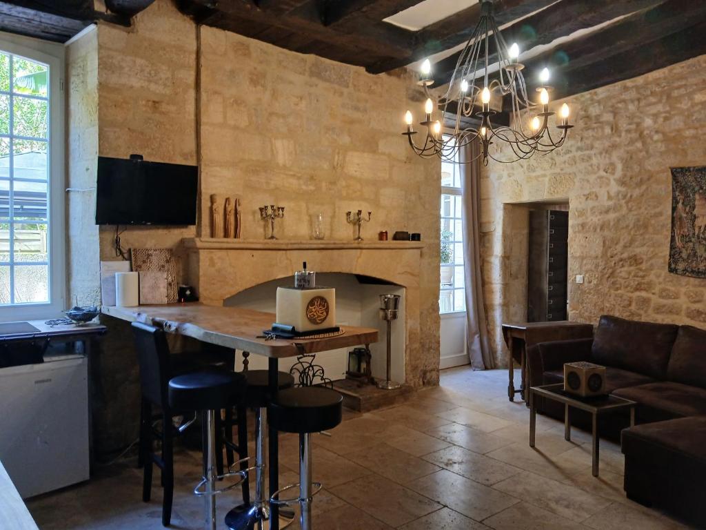 une cuisine et un salon avec une table et un canapé dans l'établissement Appartement avec jardin de 30M2 privatif centre de Sarlat, à Sarlat-la-Canéda