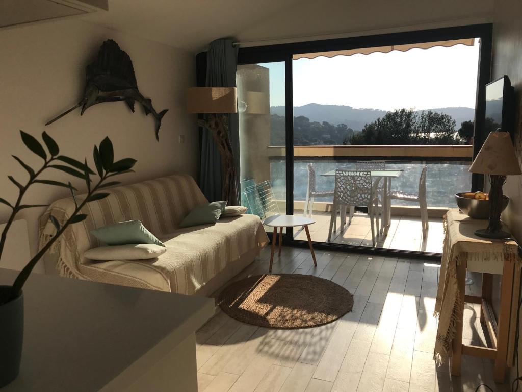 d'un salon avec un canapé et un balcon. dans l'établissement Appartement La Croix Valmer, Golfe de Saint Tropez, à La Croix-Valmer