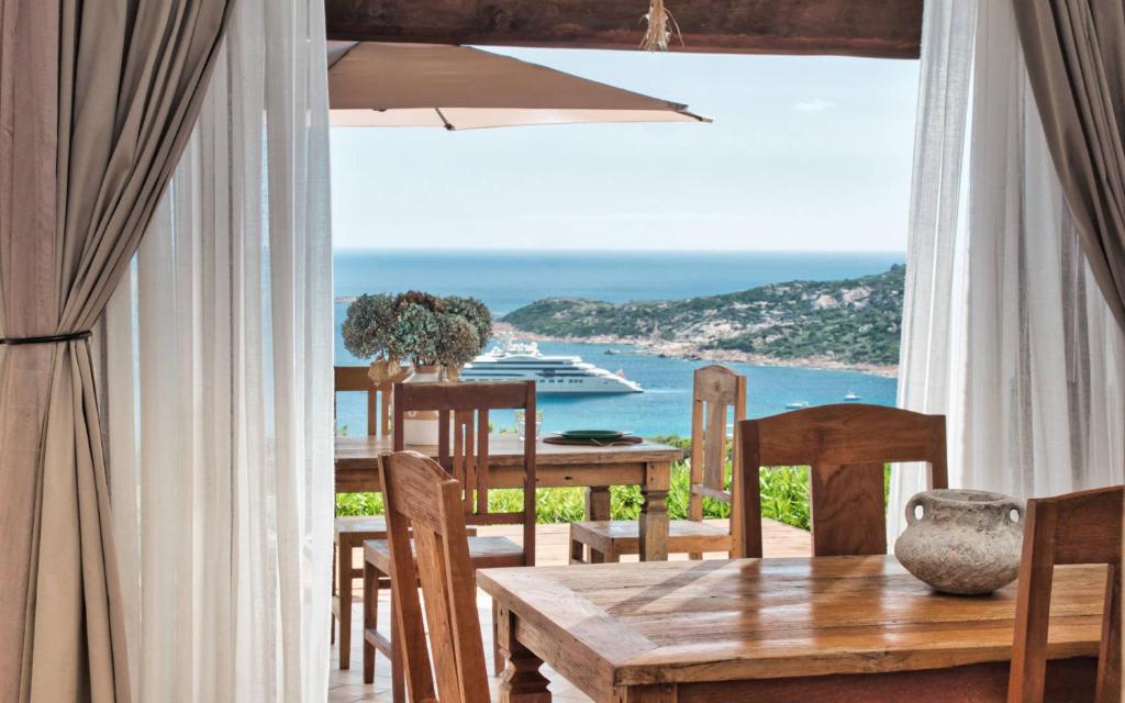 a dining room with a table and a view of the ocean at Le Terrazze Sul Pevero in Porto Cervo