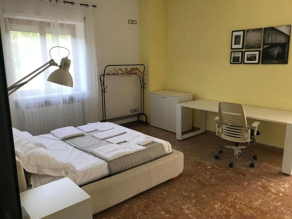 a bedroom with a bed and a desk and a chair at Forconium in LʼAquila
