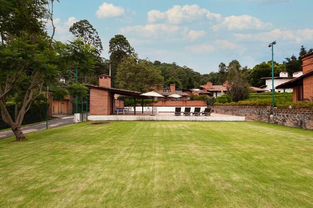 a large grassy yard with a building at Incredible Property with Huge Garden and Pool! in Valle de Bravo