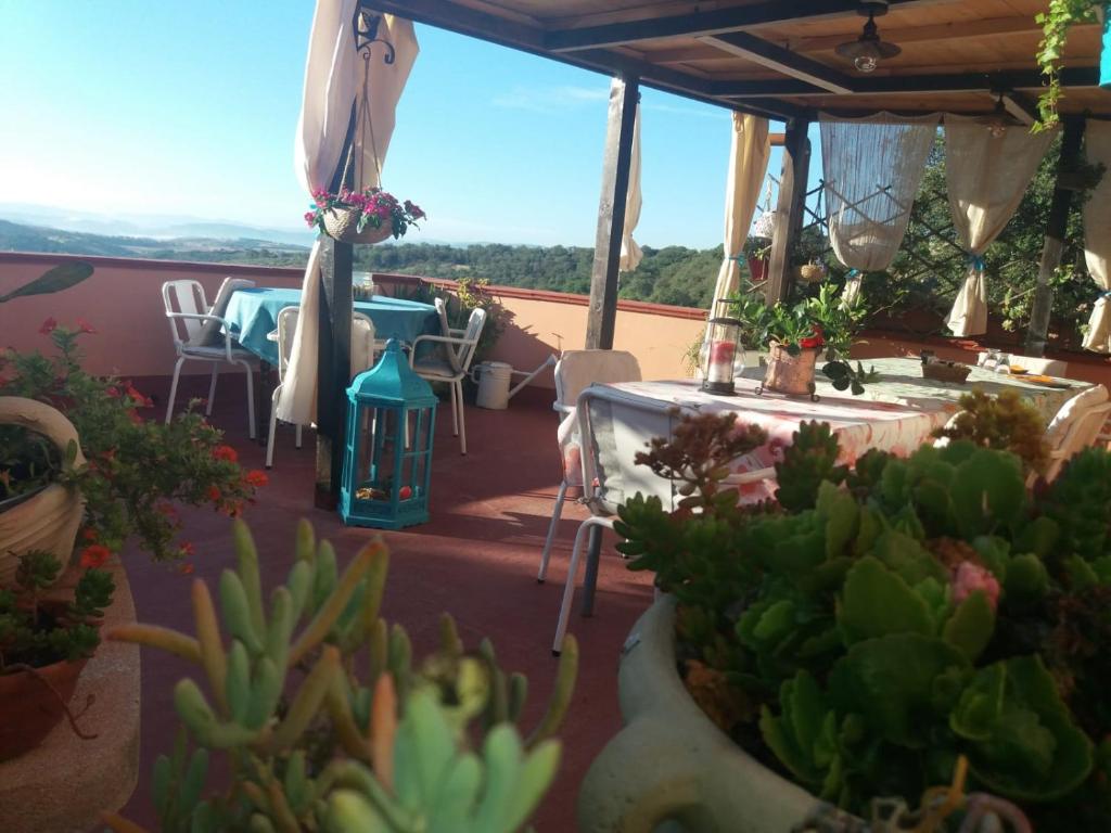 a patio with tables and chairs and potted plants at Belli come il Sole in Serri