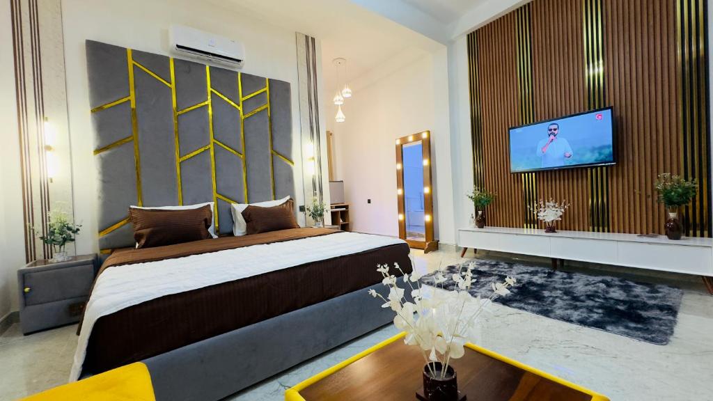 a bedroom with a large bed and a flat screen tv at Holiday Homes Guest Inn - Ella in Ella