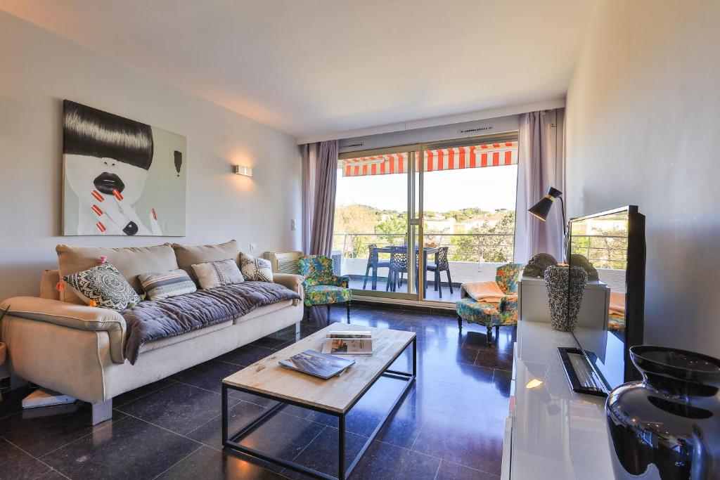 un salon avec un canapé et une table dans l'établissement Centre St Tropez - 2 Pièces -Clim Piscine Parking, à Saint-Tropez