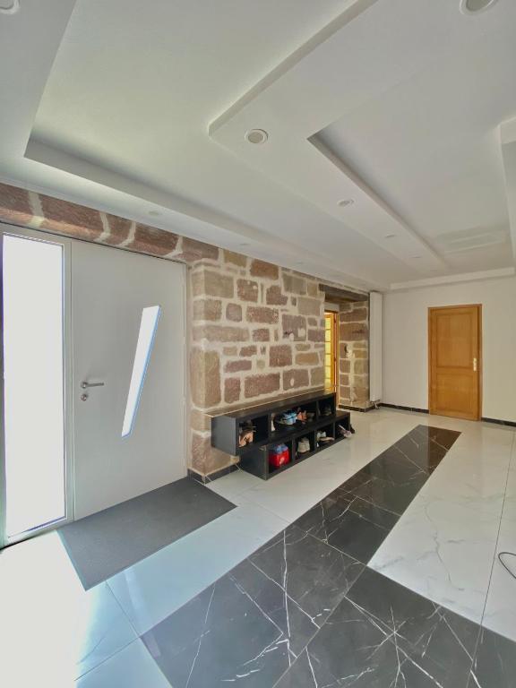 un salon avec un mur en pierre et une cheminée dans l'établissement Chambres d'hôtes - La correziene, à Allassac