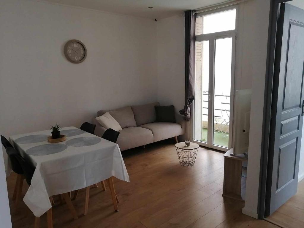 un salon avec une table et un canapé dans l'établissement Le Castel St Roch, à Toulon