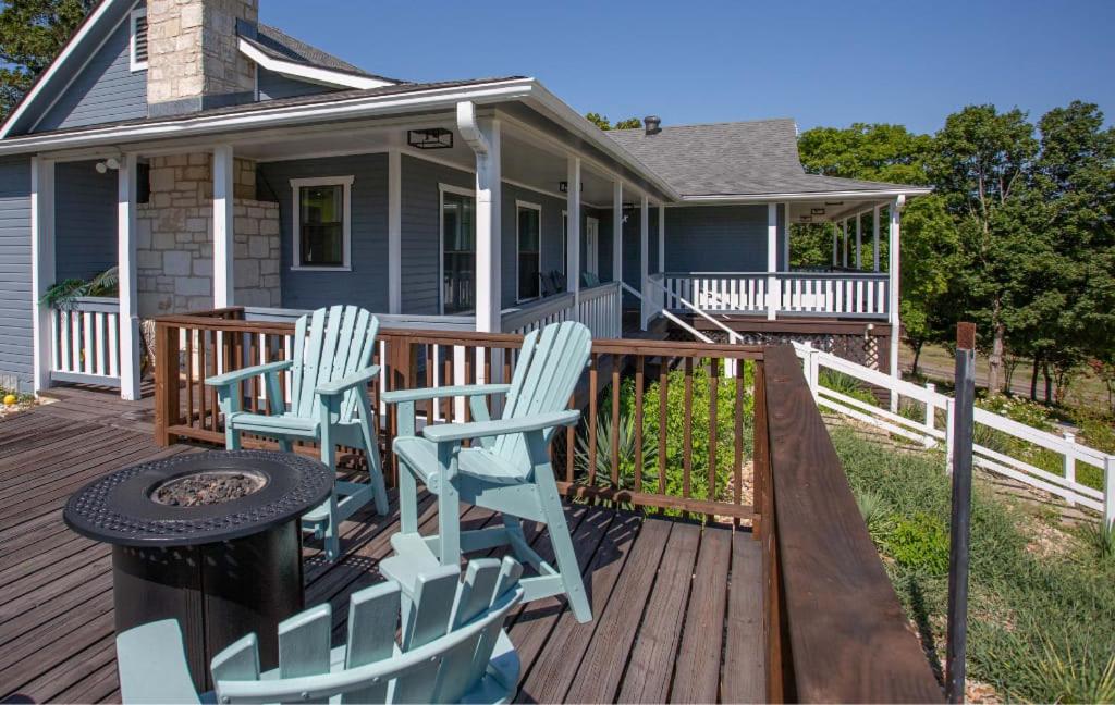 - une terrasse couverte avec 2 chaises et un grill dans une maison dans l'établissement Large patio and hot tub near wine country, à Fredericksburg
