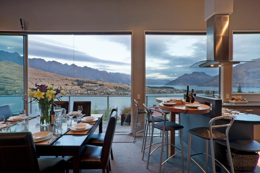 a restaurant with tables and chairs and a view of the water at Highview Terrace by Amazing Accom in Queenstown
