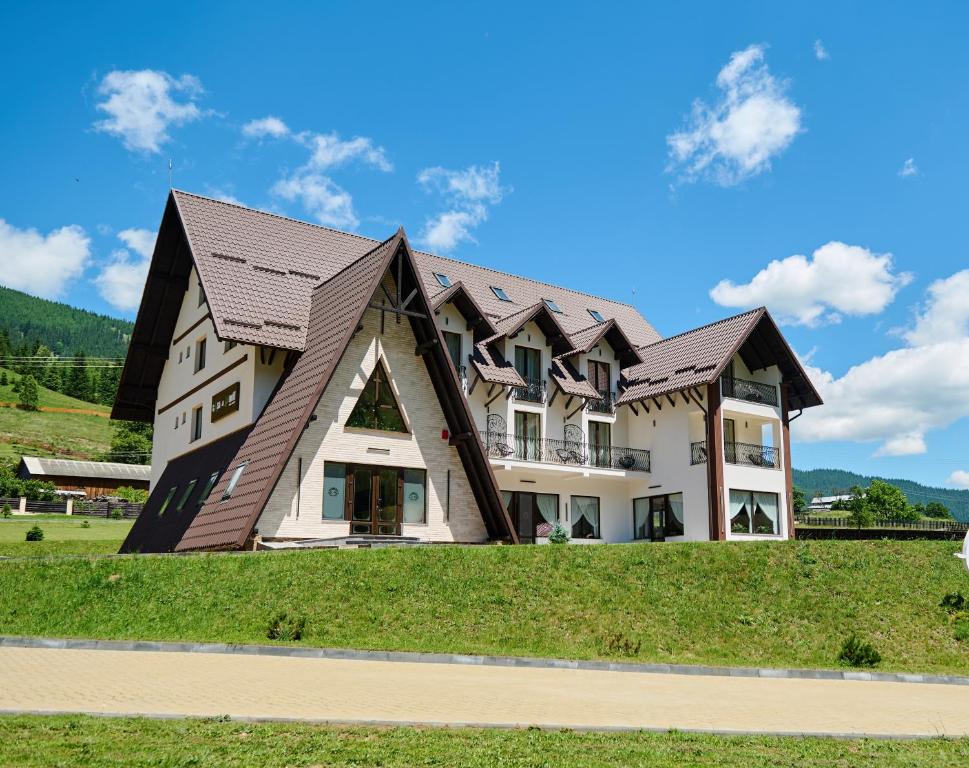 a large house with a gambrel roof at Casa del Monte - Dorna Arini in Dorna Arini