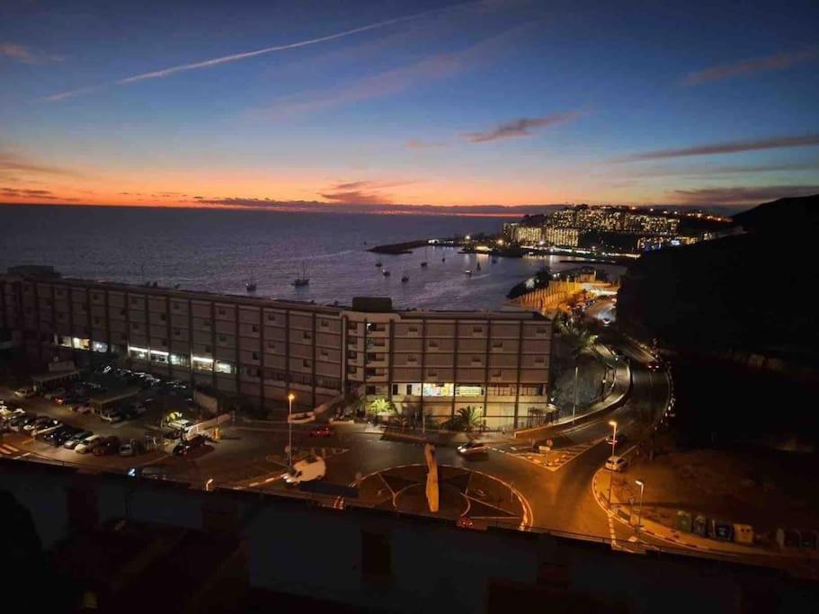a large building next to the ocean at night at Apartamento en Patalavaca, Granada 1, Arguineguin, Mogán in Patalavaca