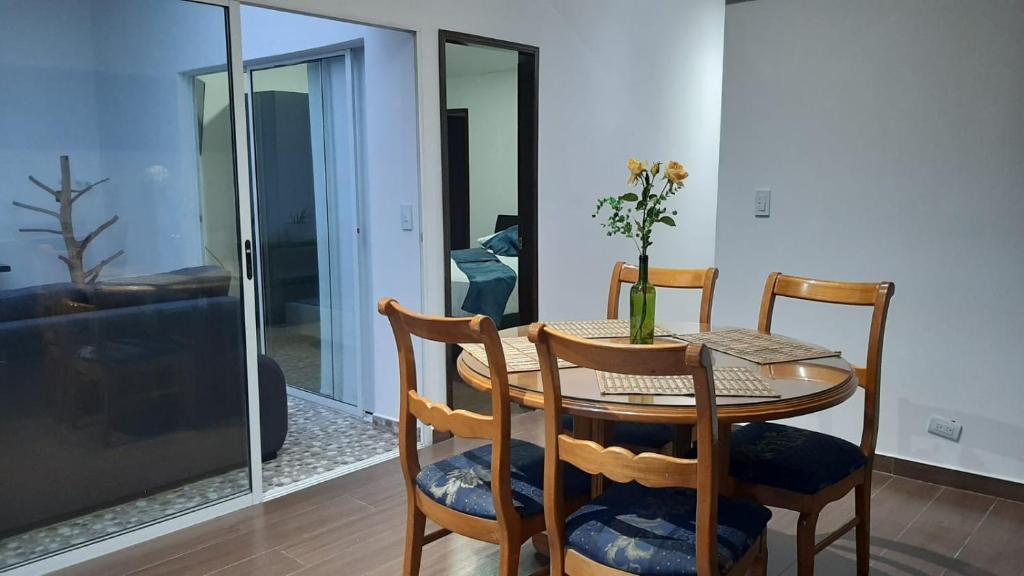 a table and chairs with a vase of flowers on it at Apartamento en un 4to piso cerca al coliseo en Armenia in Armenia