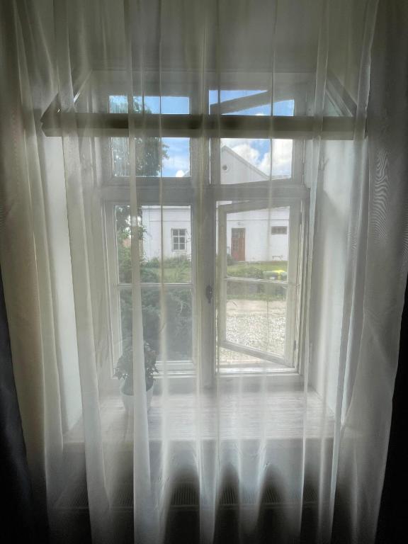 a window with white curtains in a room at Katrīnas apartamenti in Kuldīga