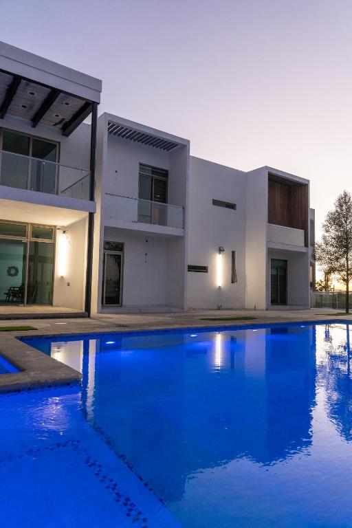 a house with a large swimming pool in front of it at La Cascada Hotel Boutique in Juanacatlán