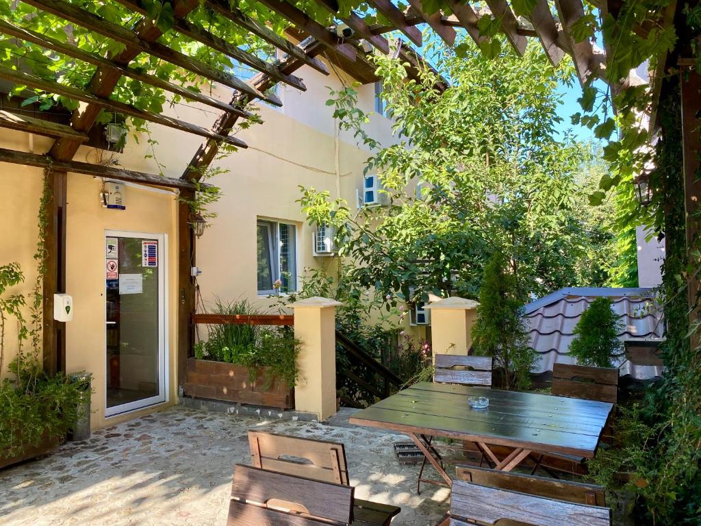 a patio with a wooden table and chairs at Casa Double M, Vama Veche in Vama Veche